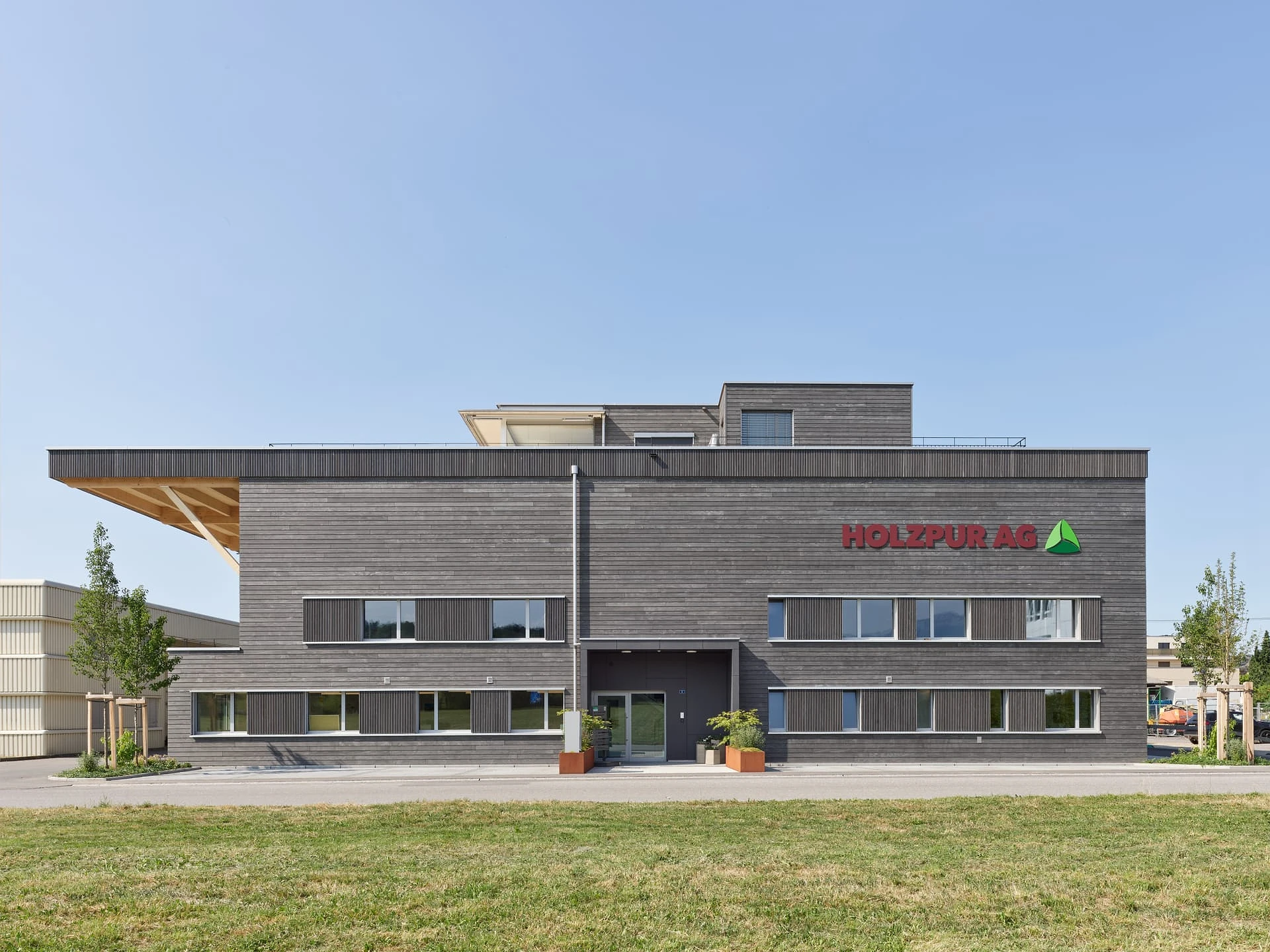Holzpur AG Sempach Station — Frontansicht mit Holzfassade